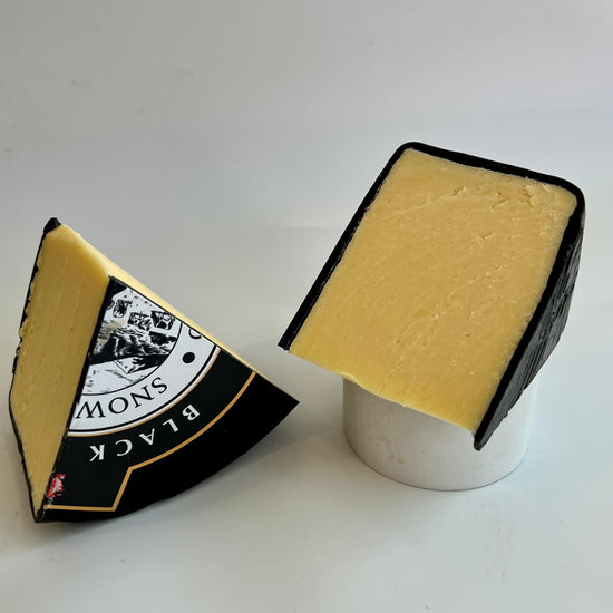 Two pieces of Black Bomber Cheese showing Black Bomber label in Cheeses of Muswell Hill